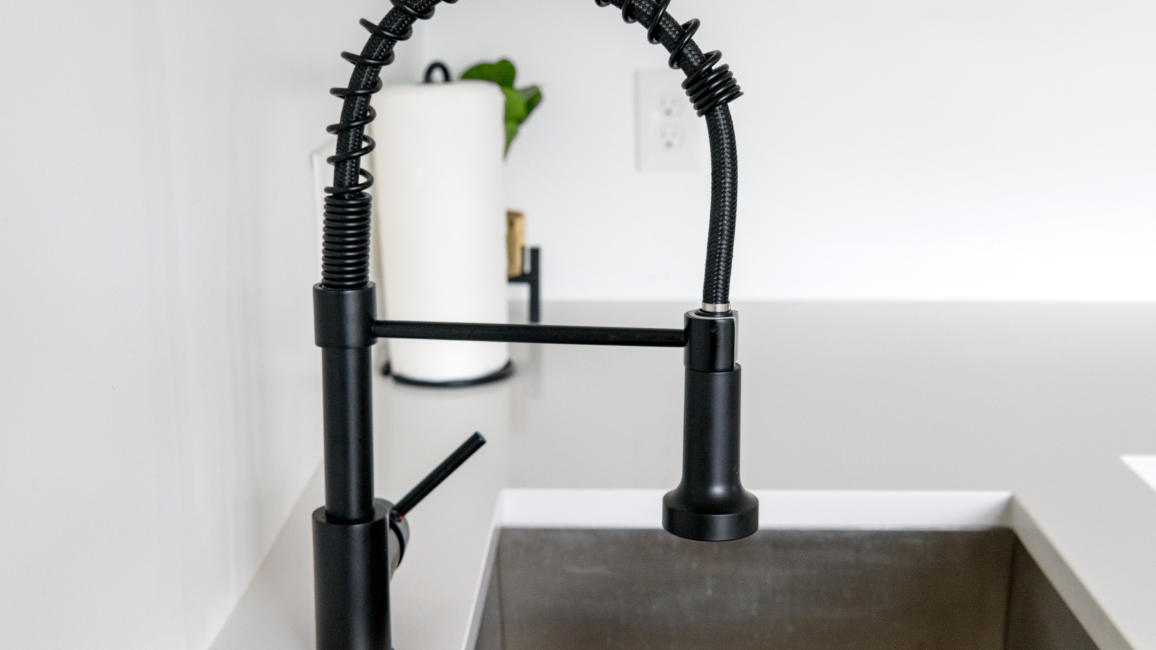 A kitchen sink with a black faucet over it