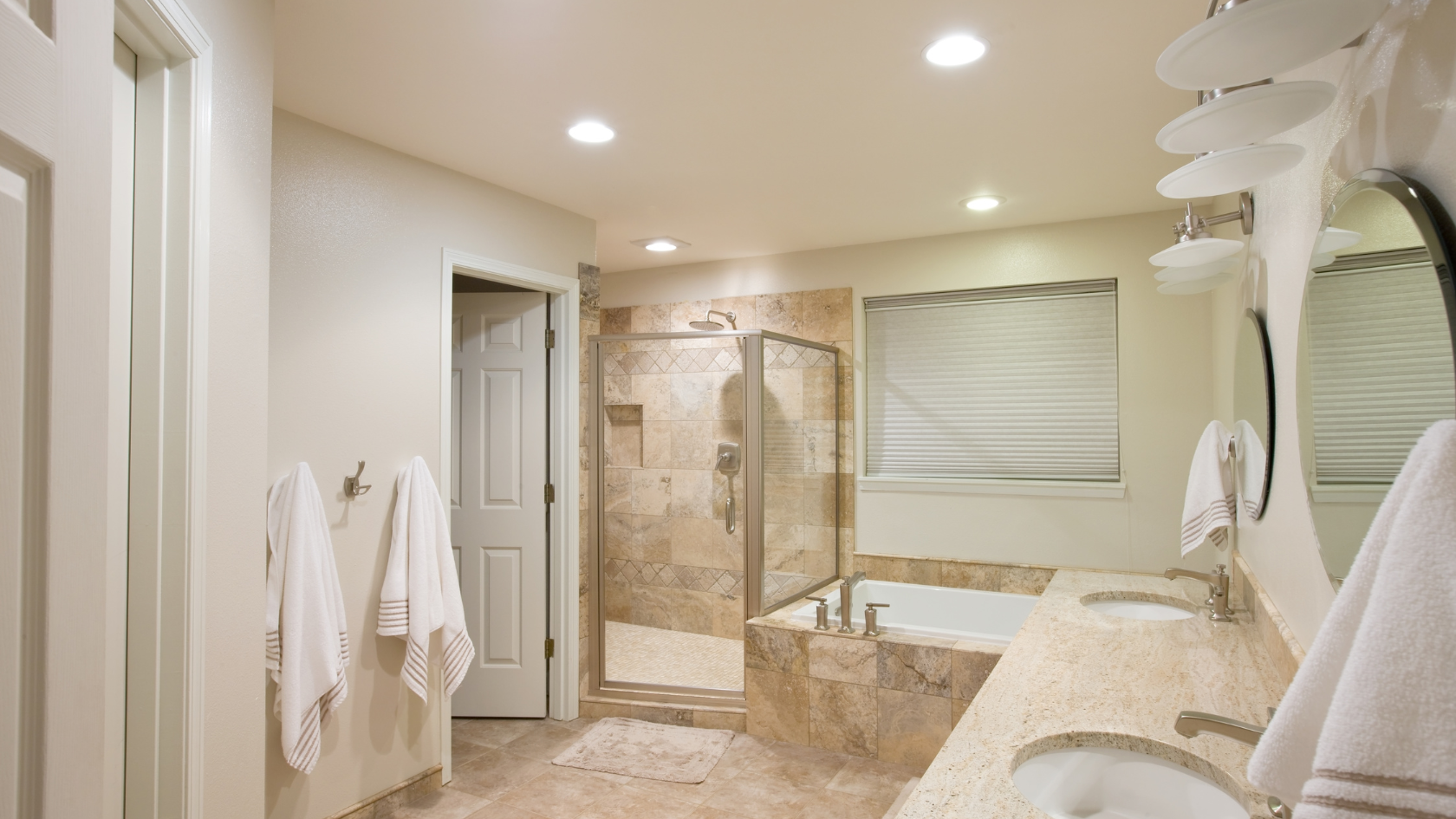 A bathroom with a tub, sink, and mirror